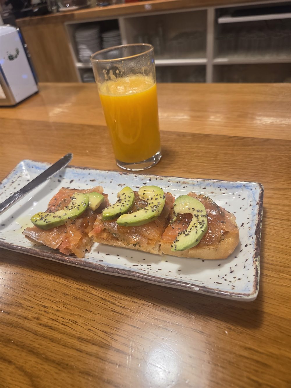 Tostada de salmón ahumado con aguacate y semillas, con zumo de naranja